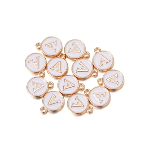 Macro view of gold alloy circular A-letter charms with white enamel inlay for DIY jewelry