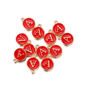 Macro detail of red enamel round charms with gold metal letter A for DIY jewelry