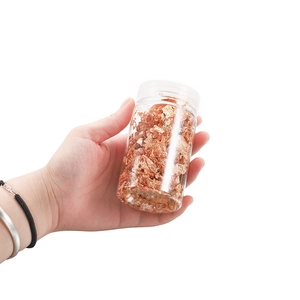 Macro shot of rose gold metallic foil flakes in a jar for nail art and DIY crafts