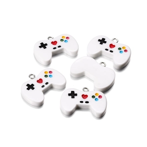 Close-up of white resin game controller charms with silver metal rings for DIY jewelry