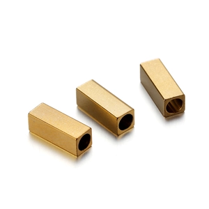 Close-up of three golden rectangular stainless steel beads with precision hole for jewelry DIY