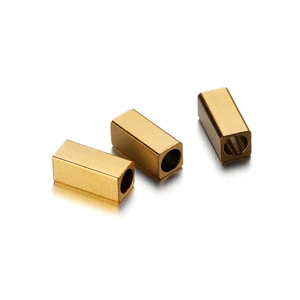 Macro shot of three golden rectangular stainless steel spacer beads with smooth finish