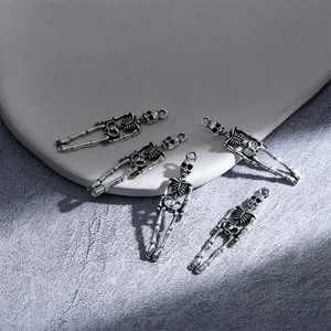 Dettaglio macro di ciondoli a scheletro argento antico per gioielli Halloween DIY