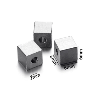 Macro detail of 6mm square stainless steel beads with a 2mm hole for DIY jewelry making