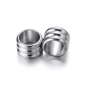 Vue macro de perles cylindriques en acier argenté avec détails de texture triple anneau