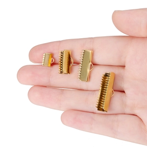 Golden stainless steel ribbon crimp ends in four sizes shown on palm for scale