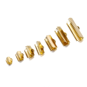 Macro view of golden polished ribbon crimp ends in seven sizes for DIY jewelry making