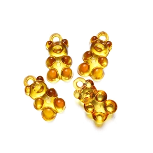 Close-up of four amber transparent resin bear charms for DIY jewelry and hair accessories