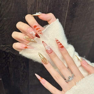 Handmade stiletto press-on nails with 3D floral accents and golden metallic wave patterns