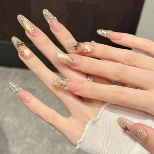 Brown bow press-on nails with champagne gold glitter, pearls, and cat eye finish