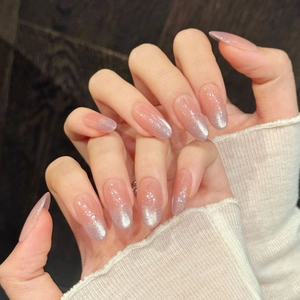 Short almond press-on nails with nude pink cat-eye base and silver glitter gradient