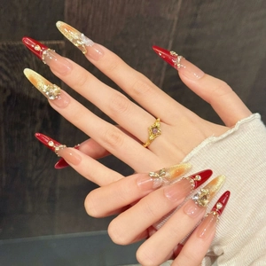 Handmade red and champagne gold glitter press-on nails with 3D bows and rhinestones