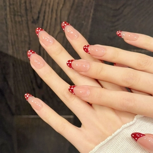 Retro almond shaped press-on nails with burgundy red French tips and white polka dots