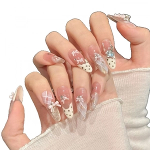 Sweet pink and white press-on nails with 3D bows, pearls, and sparkling rhinestones