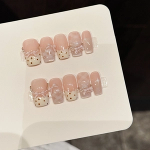 Pink and white handmade press-on nails with 3D bows, dots and plaid patterns