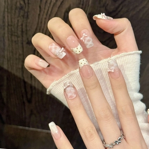 Handmade pink bow press-on nails with checkered patterns and delicate 3D butterfly charms