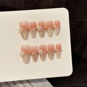 Pink and champagne gold pearl press-on nails with 3D white flowers and gradient cat-eye effect
