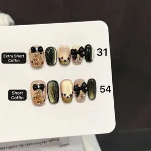 Star Butterfly press-on nails with black bows and cat eye gold shimmer effect