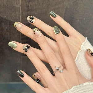 Star Butterfly press-on nails with dark green cat eye, black bows, and star accents