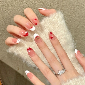 Handmade cherry press-on nails with red hearts and bows on almond shape french tips