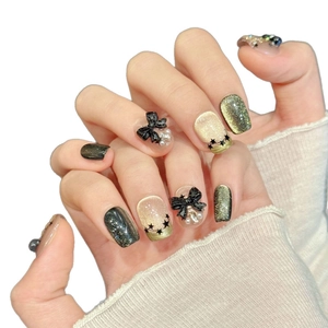 Star Butterfly Black Gold press-on nails with 3D bows and pearls on a white background