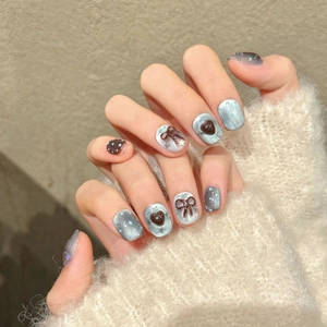 Blue and brown handmade press-on nails with silver cat-eye base and 3D bow accents