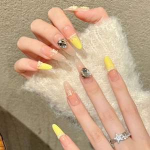 Handmade yellow French almond press-on nails with 3D bows, pearls, and large rhinestones
