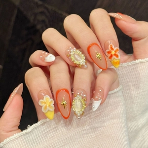 Almond-shaped press-on nails with embossed flowers, pearls, and orange French style