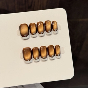 Brown cat eye press-on nails with white French tips and elegant square rhinestone accents