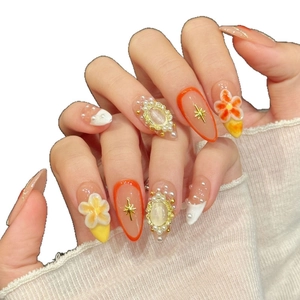 Almond shaped press-on nails with 3D floral accents, pearls, and orange French tip details