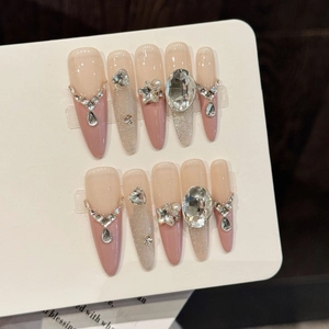 Pink diamond almond press-on nails with silver glitter gradients and crystal star charms