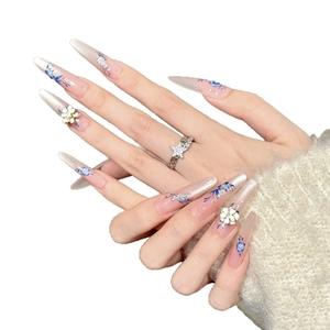 Pink gradient stiletto press-on nails with hand-painted blue flowers and white 3D accents
