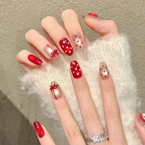 Handmade red and gold glitter press-on nails with 3D bows and festive polka dots