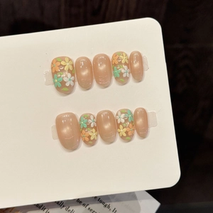 Handmade almond flower press-on nails with glitter nude base and floral art on display
