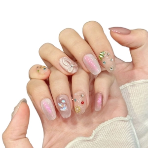 Ongles faits main œil de chat rose avec nœuds 3D et cristaux colorés de forme ovale moyenne