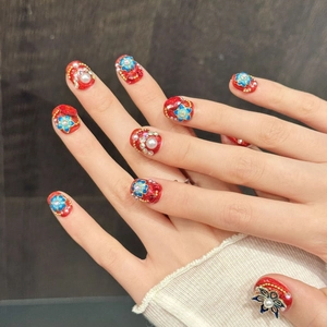 Rote Glitzer-Kunstnägel im chinesischen Stil mit blauen Emaille-Blumen und Perlen