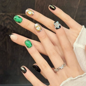 Elegant floral press-on nails and a silver butterfly ring on a wooden surface