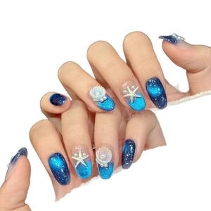 Ocean-themed handmade press-on nails with blue cat-eye gradient, starfish and pearls