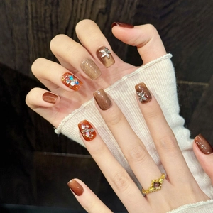 Brown cat eye press-on nails with silver floral rhinestones and glitter accents