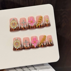 Handmade press-on nails with tiger print, 3D floral accents, and diamond cross charms