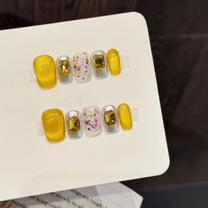 Handmade press-on nails with golden cat eye effect, yellow rhinestones and glitter accents