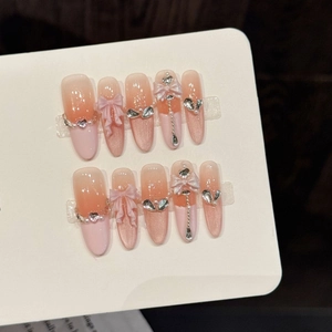 Handmade pink gradient cat-eye press-on nails with 3D ribbons and rhinestones