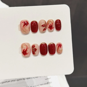 Red and nude pink press-on nails with golden floral patterns and auspicious clouds
