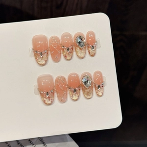 Pink gradient press-on nails with cat-eye glitter, pearls, and rhinestone accents