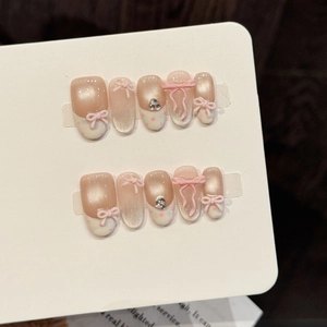 Pink cat-eye press-on nails with 3D bows and rhinestones in balletcore style