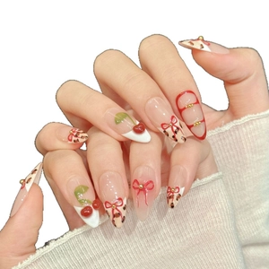 Sweet pink press-on nails featuring cherry designs, leopard print, and red bows in almond shape