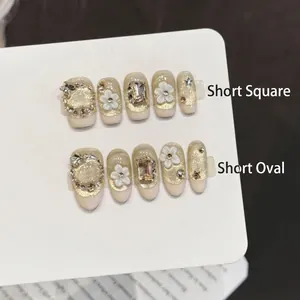 Handmade press-on nails with champagne gold cat-eye texture and 3D white flower design