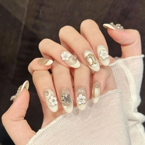 Champagne gold glitter press-on nails with 3D white flowers and sparkling rhinestones