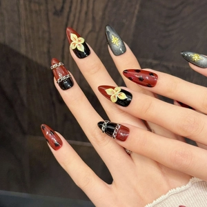 Faux ongles stiletto rouge et noir effet œil de chat avec chaînes et motifs floraux