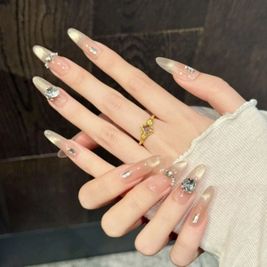 Long almond press-on nails with nude gold glitter and luxury rhinestone embellishments